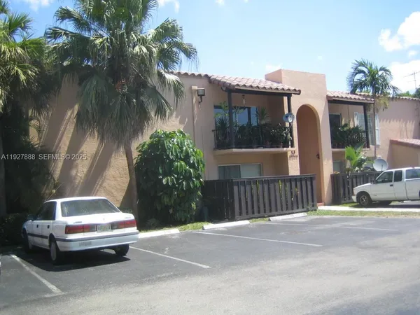 a view of a street with a building and palm trees