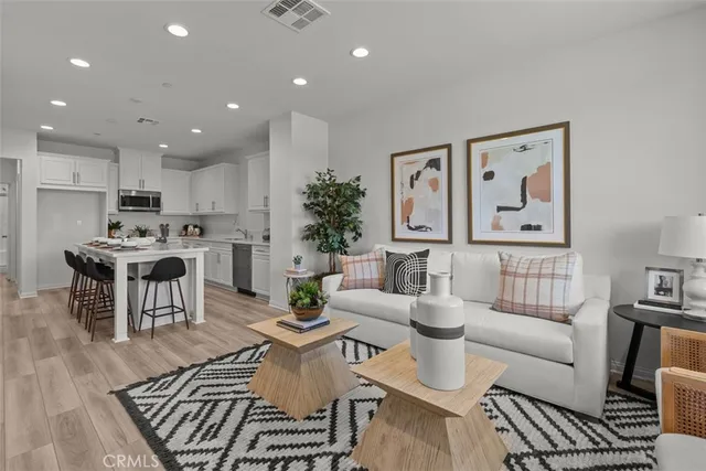 a view of a dining room with furniture a kitchen and wooden floor