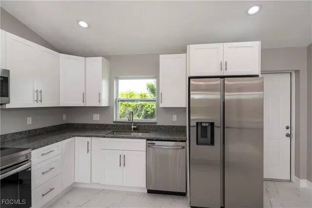 a kitchen with a refrigerator sink and cabinets