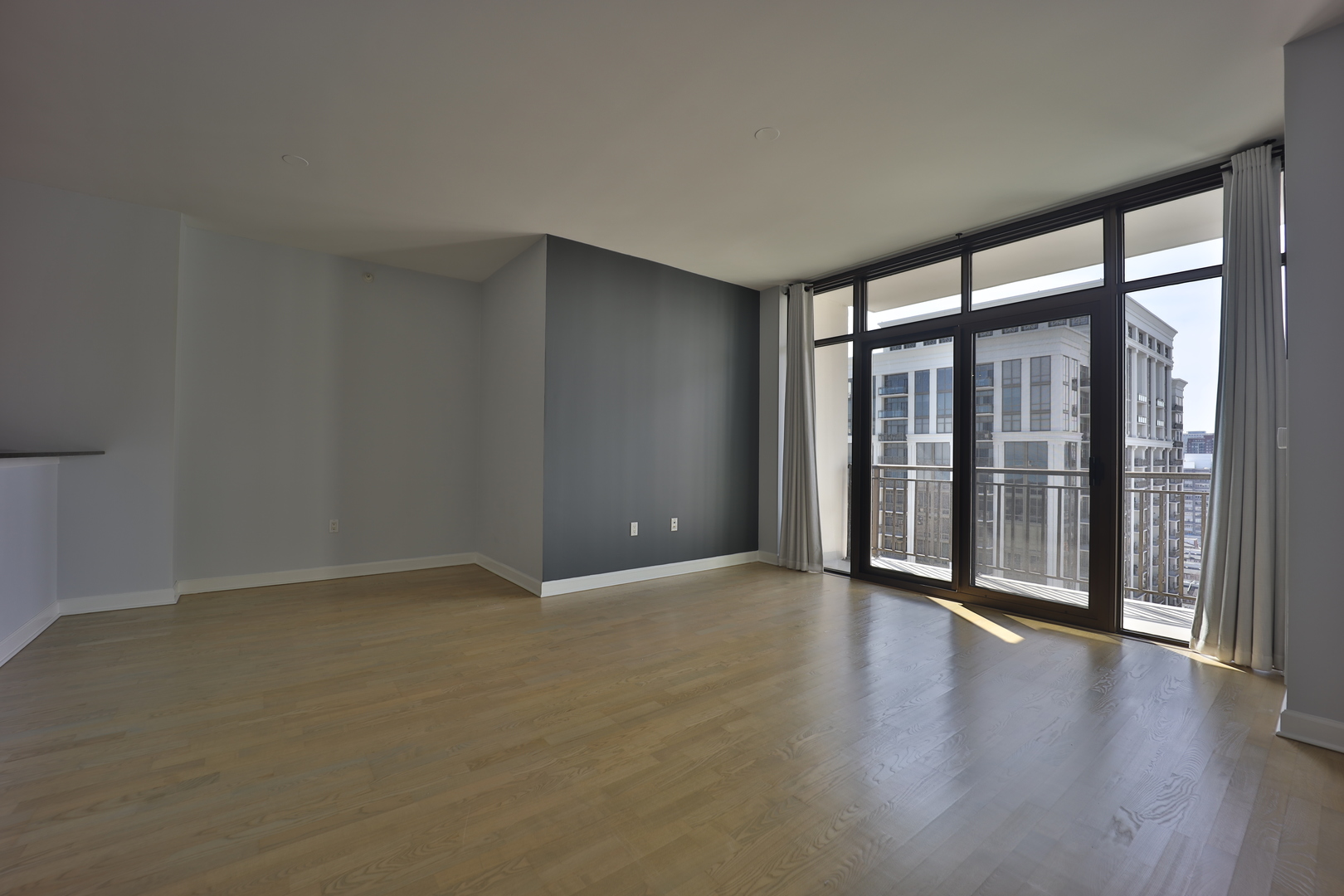 233 East 13th Street, Unit 1708 Chicago, IL 60605 - Photo 3 of 15 an empty room with wooden floor and windows