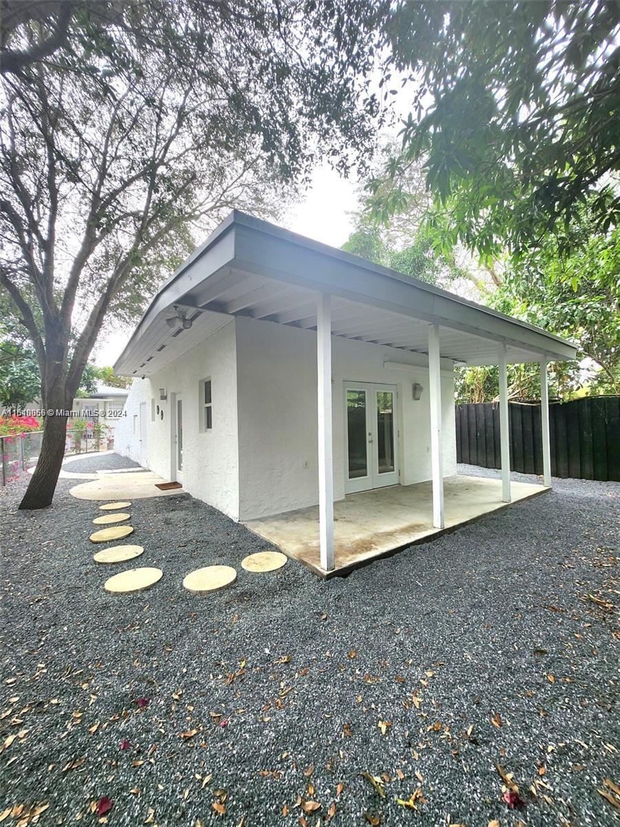 a view of a house with a yard and large tree
