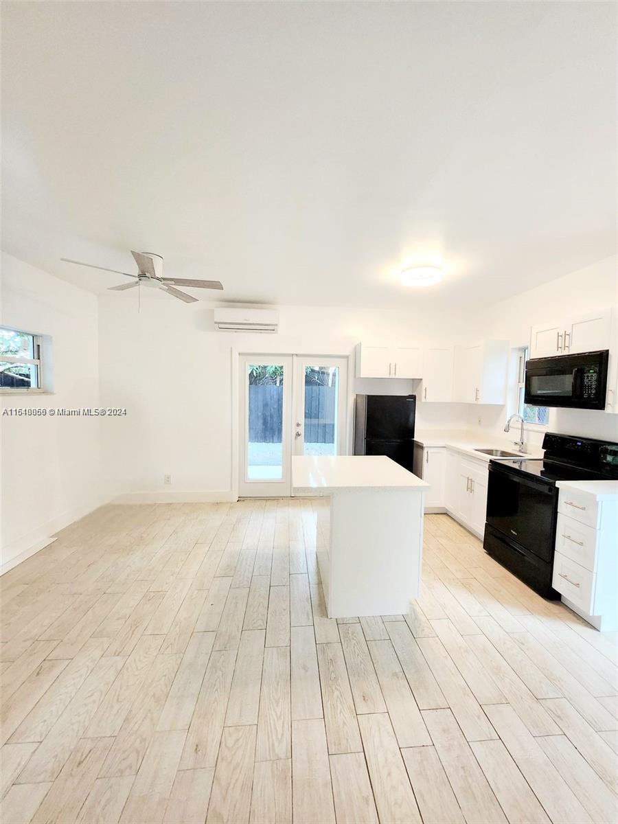 261 Northwest 50th Street, Unit R Miami, FL 33127 - Photo 3 of 10 a living room with furniture and a flat screen tv