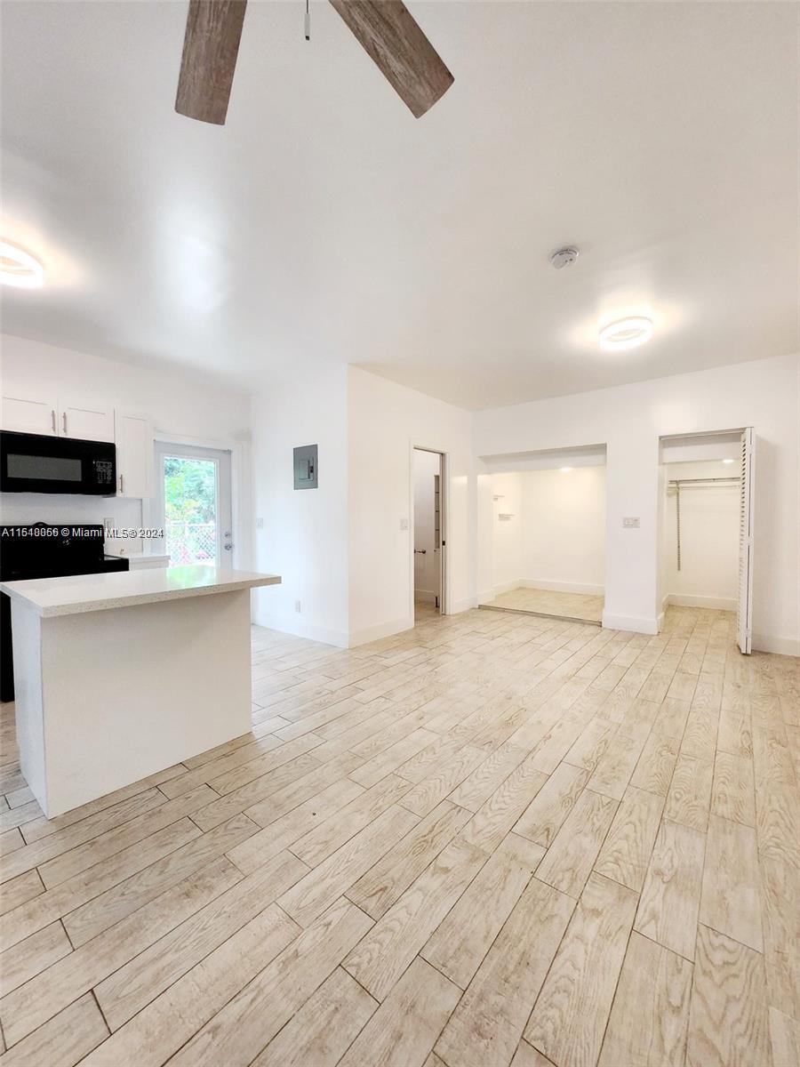 261 Northwest 50th Street, Unit R Miami, FL 33127 - Photo 5 of 10 an empty room with kitchen appliances and windows