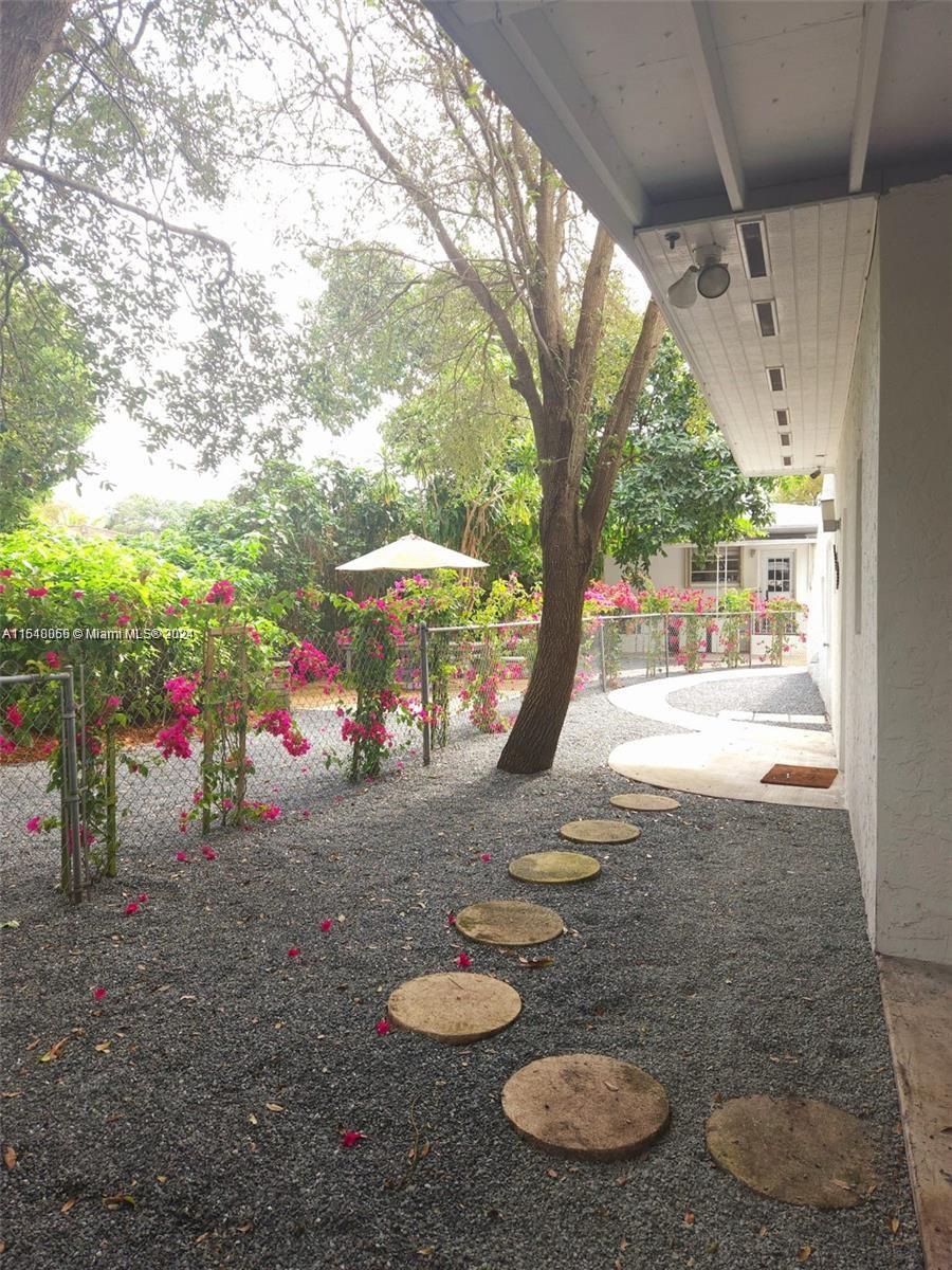 261 Northwest 50th Street, Unit R Miami, FL 33127 - Photo 9 of 10 a backyard of a house with table and chairs