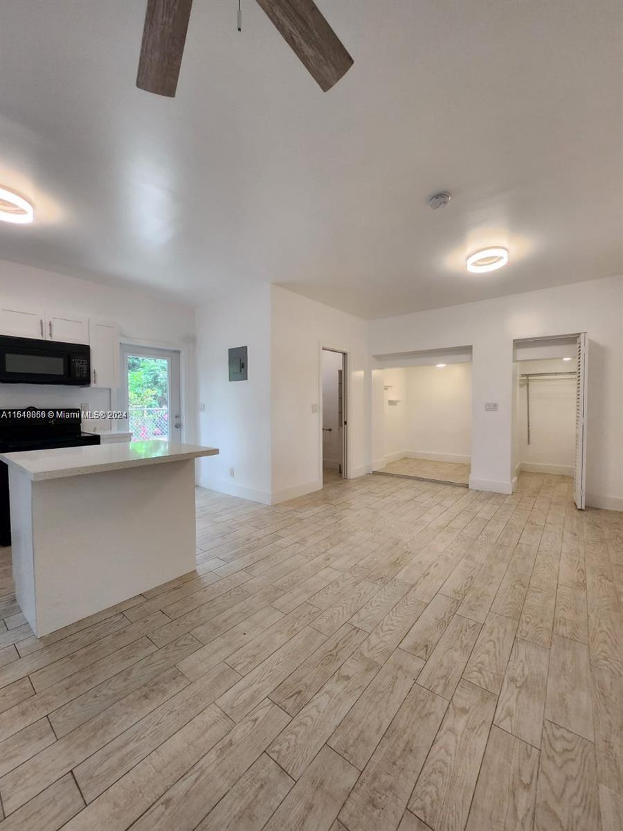 261 Northwest 50th Street, Unit R Miami, FL 33127 - Photo 10 of 10 an empty room with windows and fireplace