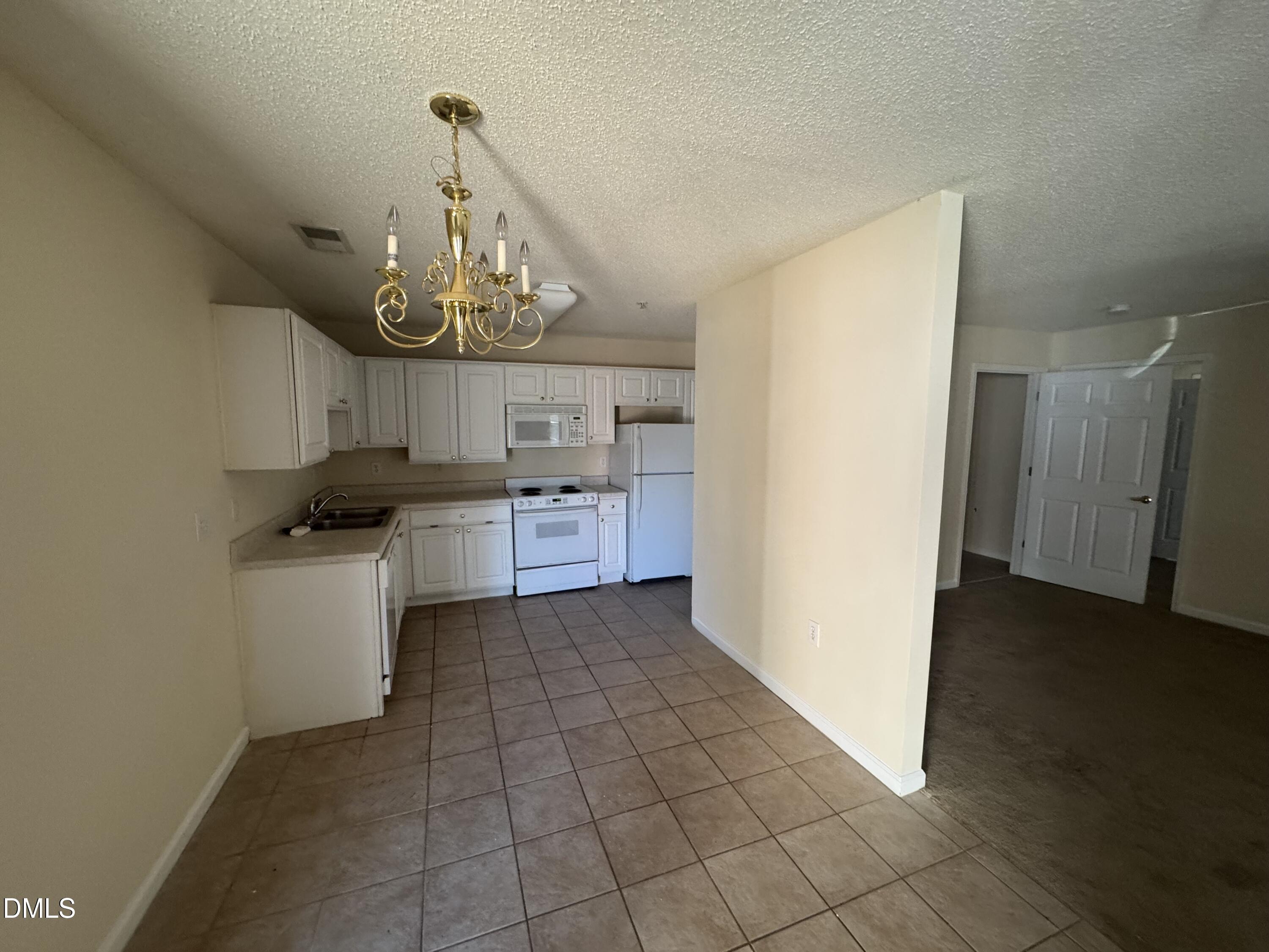 2511 Huntscroft Lane, Unit 101 Raleigh, NC 27617 - Photo 4 of 11 a kitchen with a stove a refrigerator and cabinets