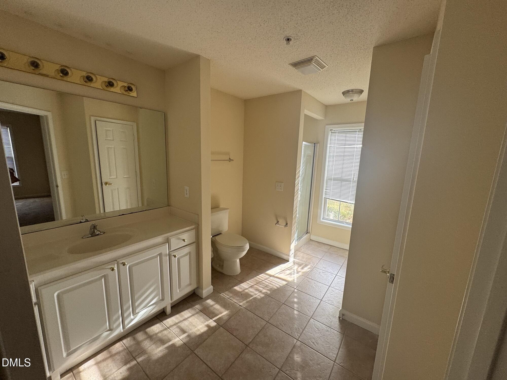 2511 Huntscroft Lane, Unit 101 Raleigh, NC 27617 - Photo 10 of 11 a bathroom with a sink a toilet and a large mirror