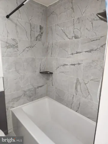 a bath tub sitting next to a white sink and vanity