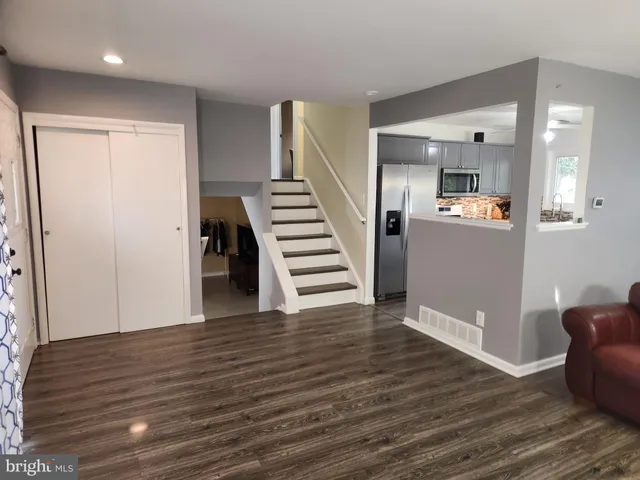 a view of a hallway with wooden floor and stairs