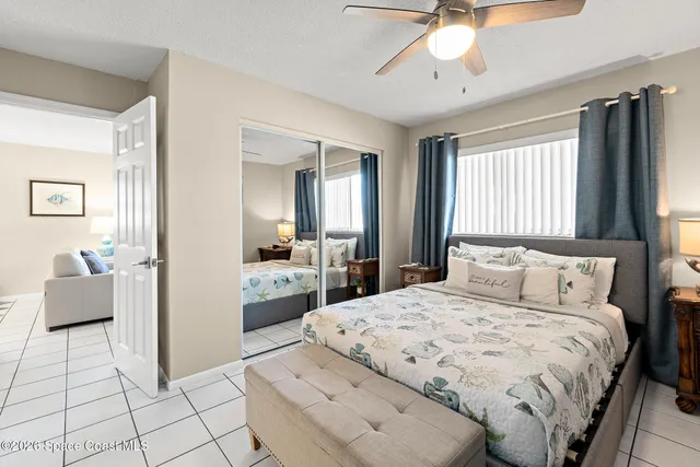 a large bedroom with a bed and glass walk in closet