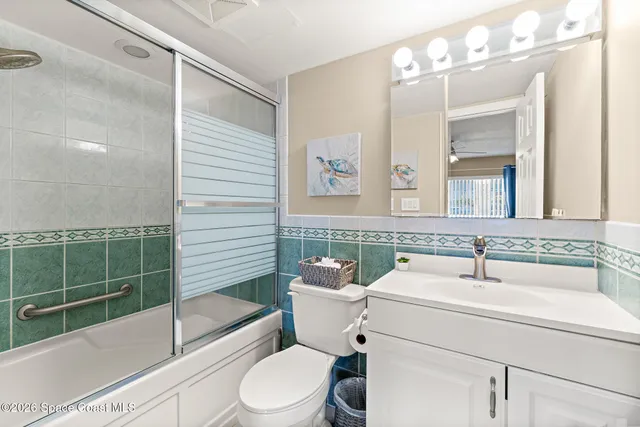 a bathroom with a sink a toilet a mirror and shower