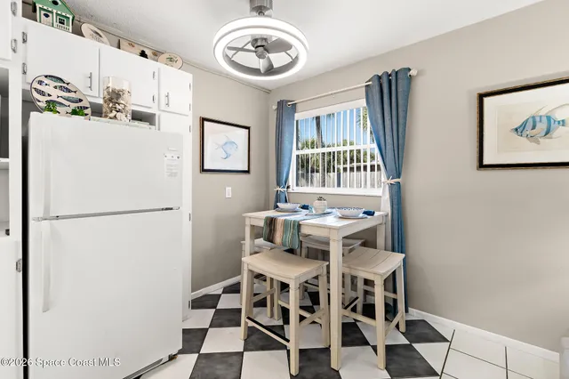 a view of a dining room with furniture and a refrigerator