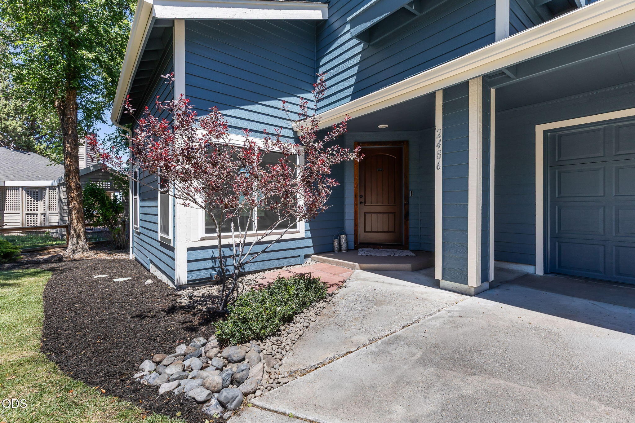 2486 Southwest Valleyview Drive Redmond, OR 97756 - Photo 2 of 55 a view of a house with a small yard plants and large tree