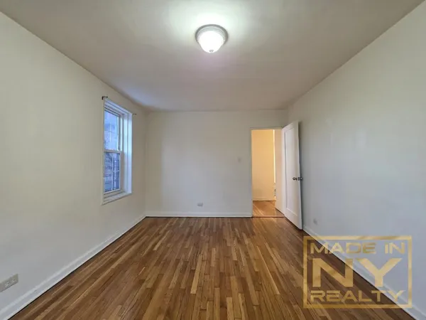 a view of room with window and wooden floor