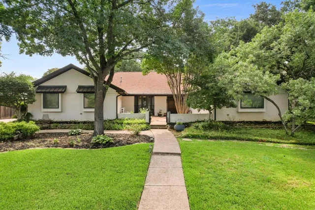 a front view of a house with a yard and trees