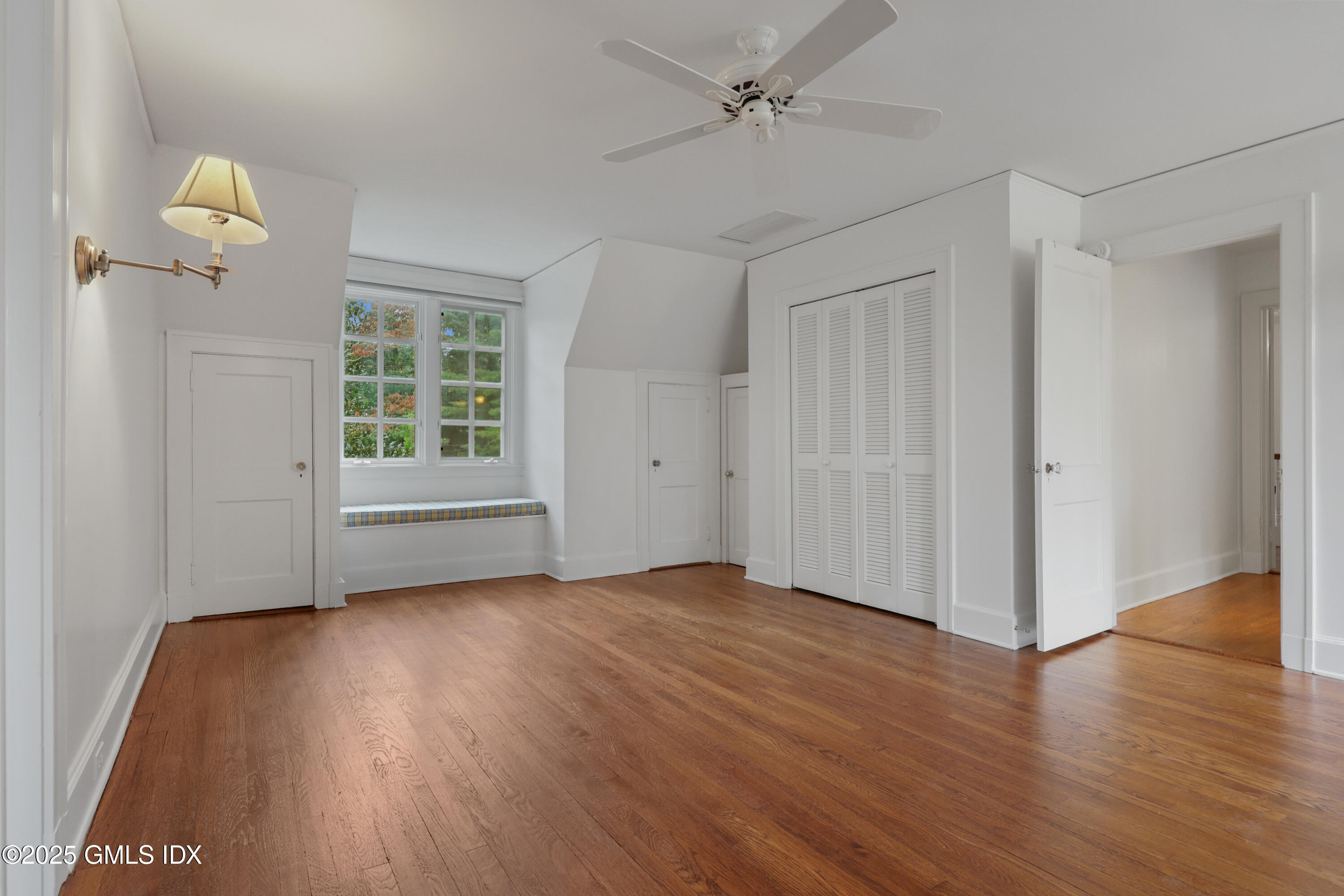 11 Stanwich Road Greenwich, CT 06830 - Photo 17 of 25 an empty room with wooden floor chandelier fan and windows