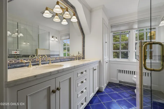 a spacious bathroom with a granite countertop sink mirror and window