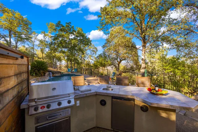 a dining room with stainless steel appliances kitchen island granite countertop a table chairs and a view of living room