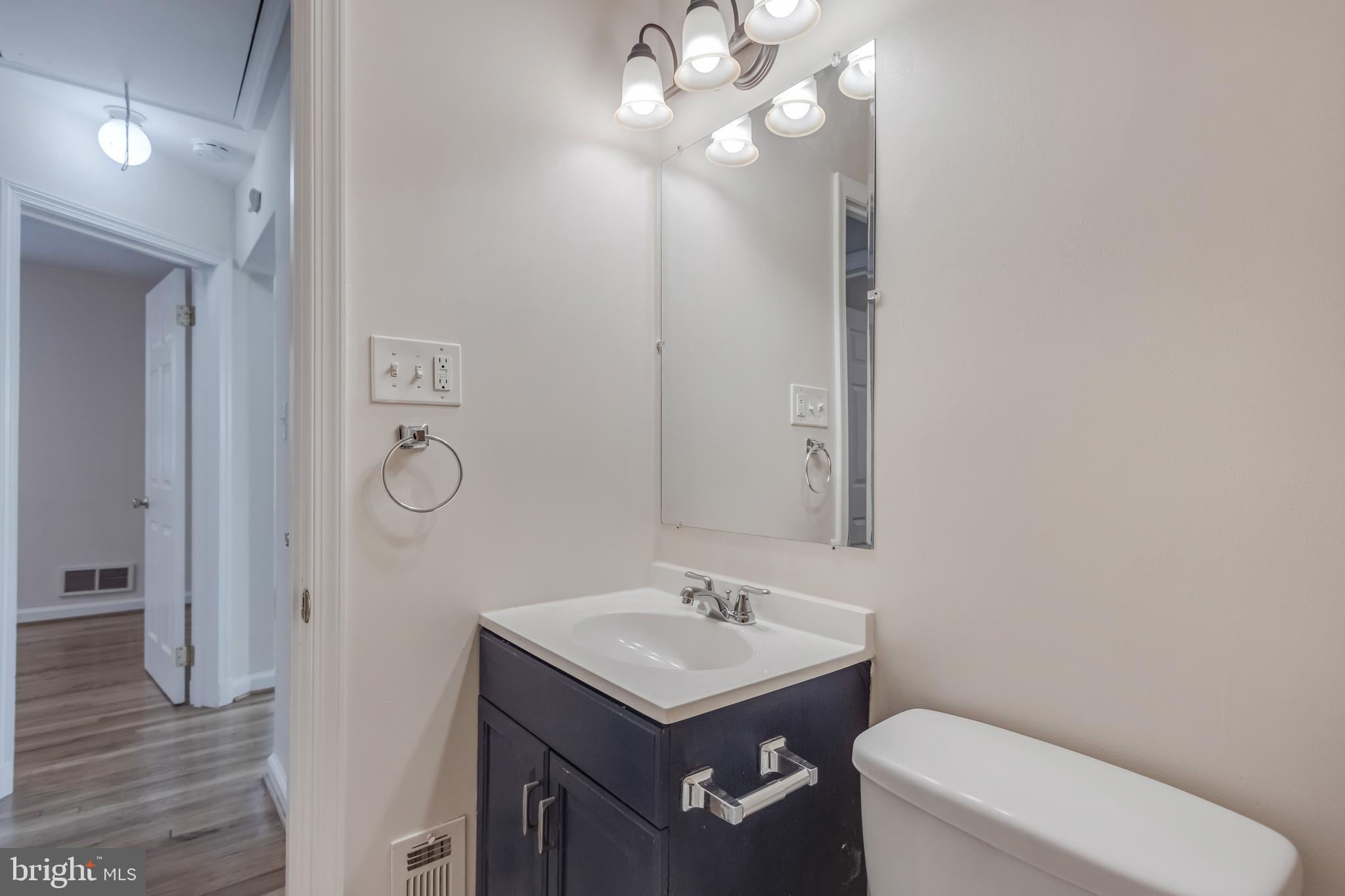 11603 Gail Street Silver Spring, MD 20902 - Photo 16 of 19 a bathroom with a toilet a sink and mirror
