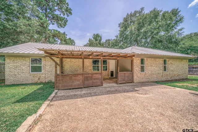 a view of a house with a yard and sitting area