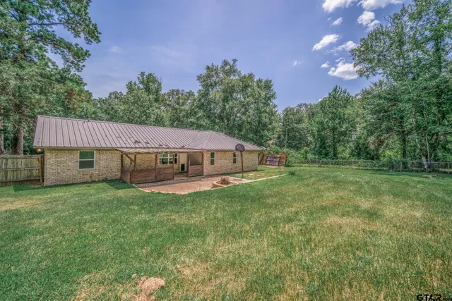 a view of a house with a big yard and large trees