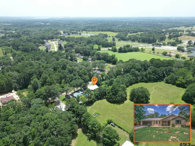 an aerial view of a house with a yard and lake view