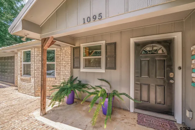 a view of an empty room with wooden floor and a ceiling fan