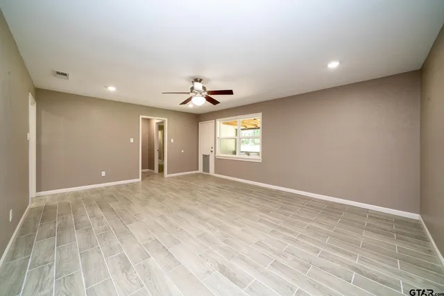 an empty room with a kitchen and a window