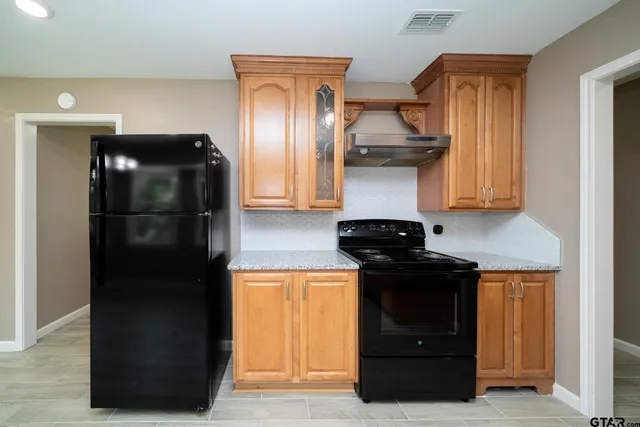a kitchen with stainless steel appliances granite countertop a sink stove and cabinets