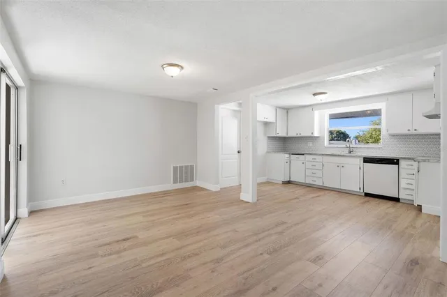 a view of a kitchen with a sink cabinets and wooden floor