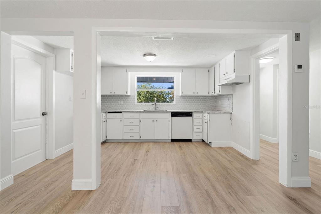 10536 Laburnum Drive Port Richey, FL 34668 - Photo 13 of 33 a kitchen with white cabinets and wooden floor