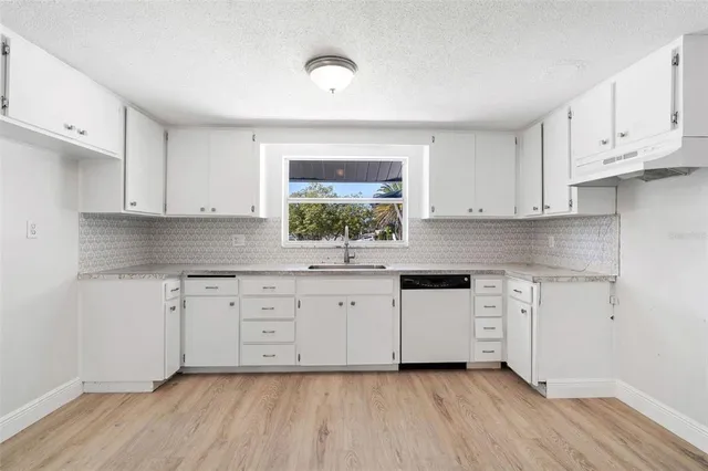 a kitchen with granite countertop white cabinets and white appliances