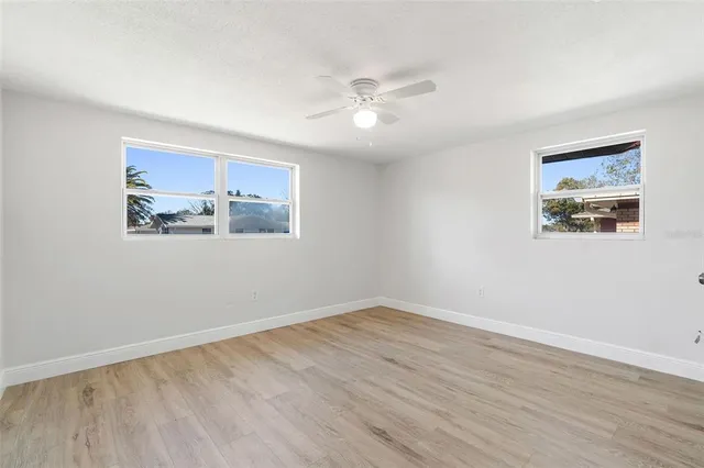 a view of a big room with wooden floor and windows in a room