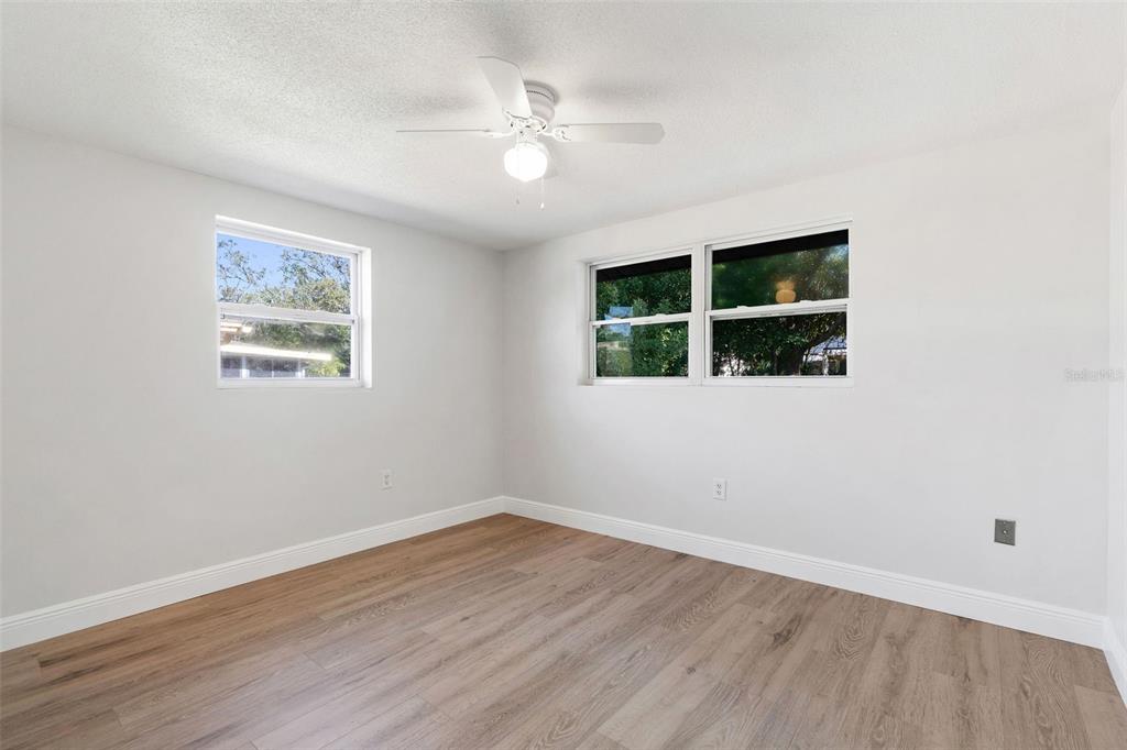 10536 Laburnum Drive Port Richey, FL 34668 - Photo 19 of 33 an empty room with wooden floor and window