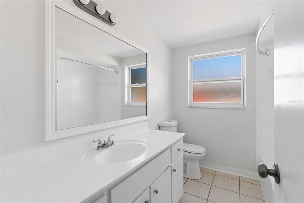 10536 Laburnum Drive Port Richey, FL 34668 - Photo 21 of 33 a bathroom with a granite countertop sink toilet and mirror