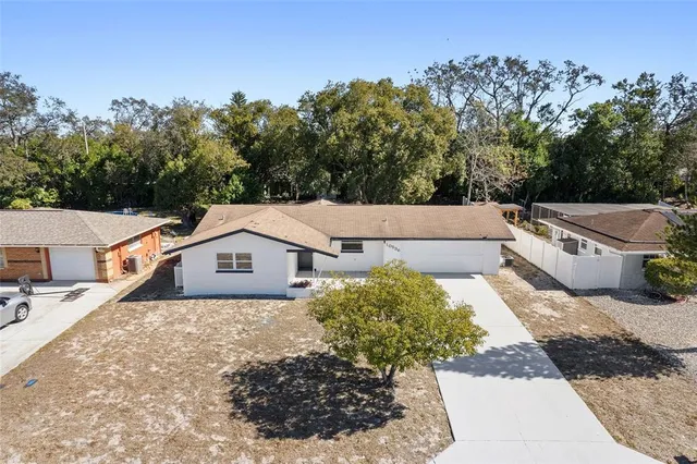 an aerial view of a house with a yard and large trees