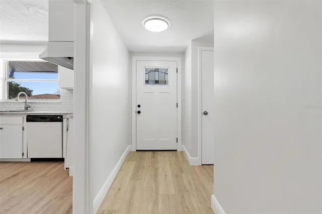 a view of a hallway with wooden floor and closet