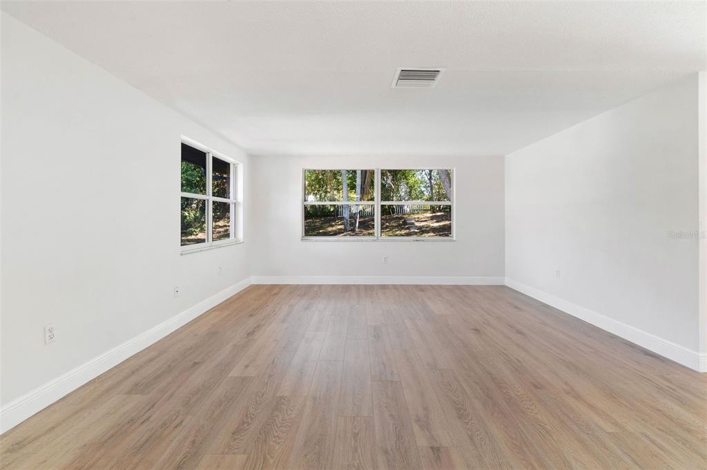 10536 Laburnum Drive Port Richey, FL 34668 - Photo 7 of 33 an empty room with wooden floor and windows