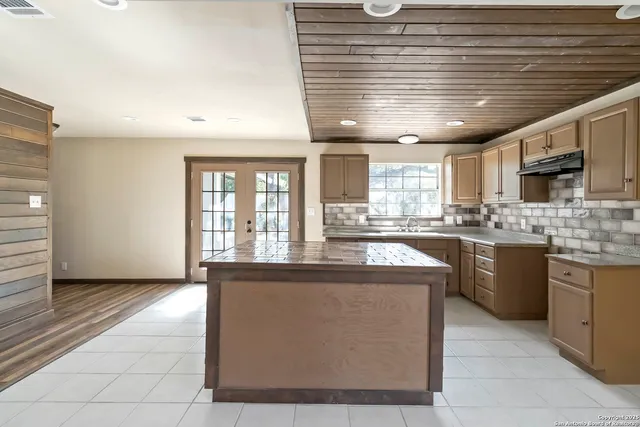 a kitchen with kitchen island granite countertop lots of counter top space and stainless steel appliances