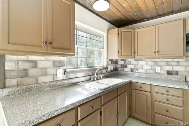 a kitchen with cabinets appliances a sink and a window