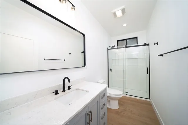 a bathroom with a sink a toilet and shower