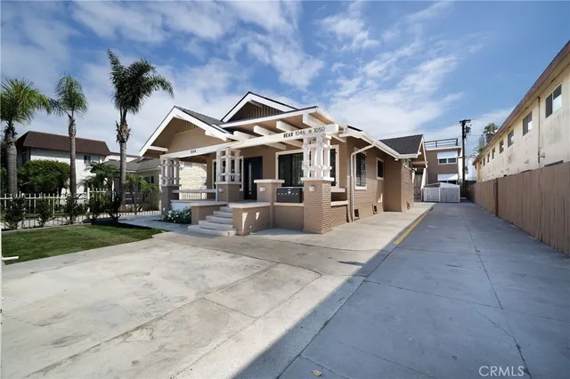 a view of a white house with a big yard and large trees