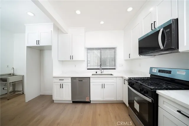 a kitchen with stainless steel appliances a sink stove and microwave