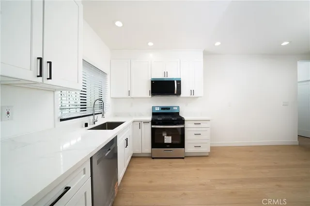 a kitchen with stainless steel appliances a stove sink and microwave