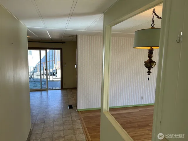 a view of a hallway with wooden floor and a bathroom