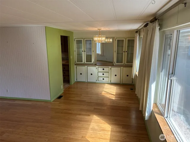 a view of a hallway with wooden floor and glass door