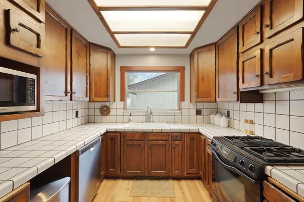 a kitchen with a sink stove top oven and cabinets