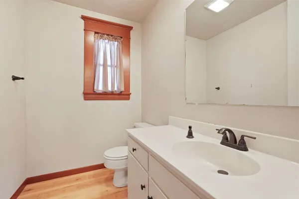 a bathroom with a toilet a sink and mirror