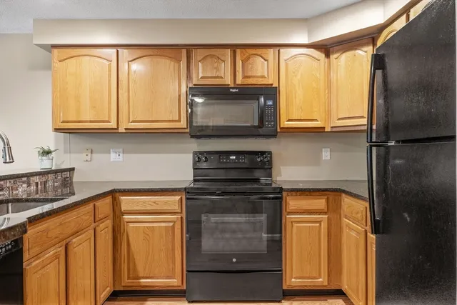 a kitchen with granite countertop cabinets stainless steel appliances and a sink