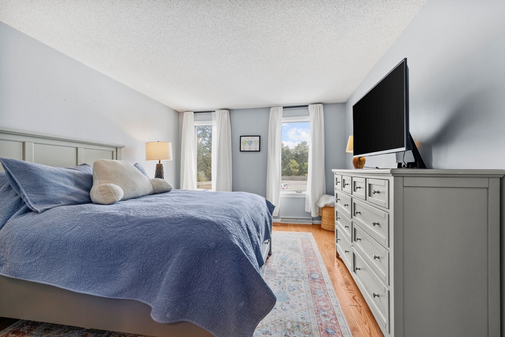 120 Abington Road, Unit 120 Danvers, MA 01923 - Photo 18 of 31 a bed room with a bed tv and a fireplace